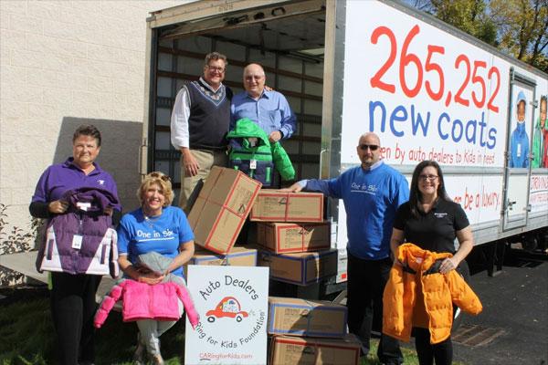 Representatives from participating auto dealers in Montgomery County show off a selection of the more than 300 free winter coats delivered to the North Penn YMCA during Wednesday's Driving Away the Cold event.